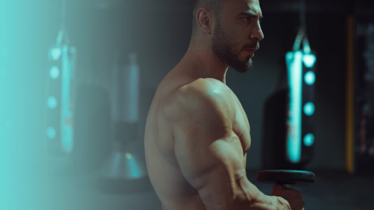 Homme torse nu tenant une barre en salle de sport, illustration de la prise de masse du hardgainer
